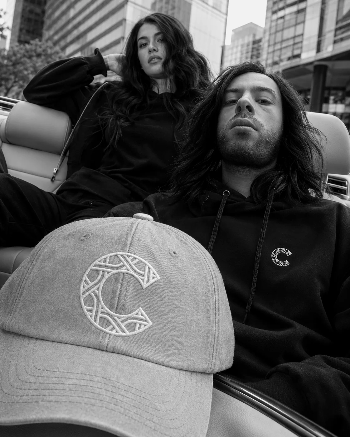 Casquette sable CHVMS au premier plan, hoodie noir porté à l'arrière-plan