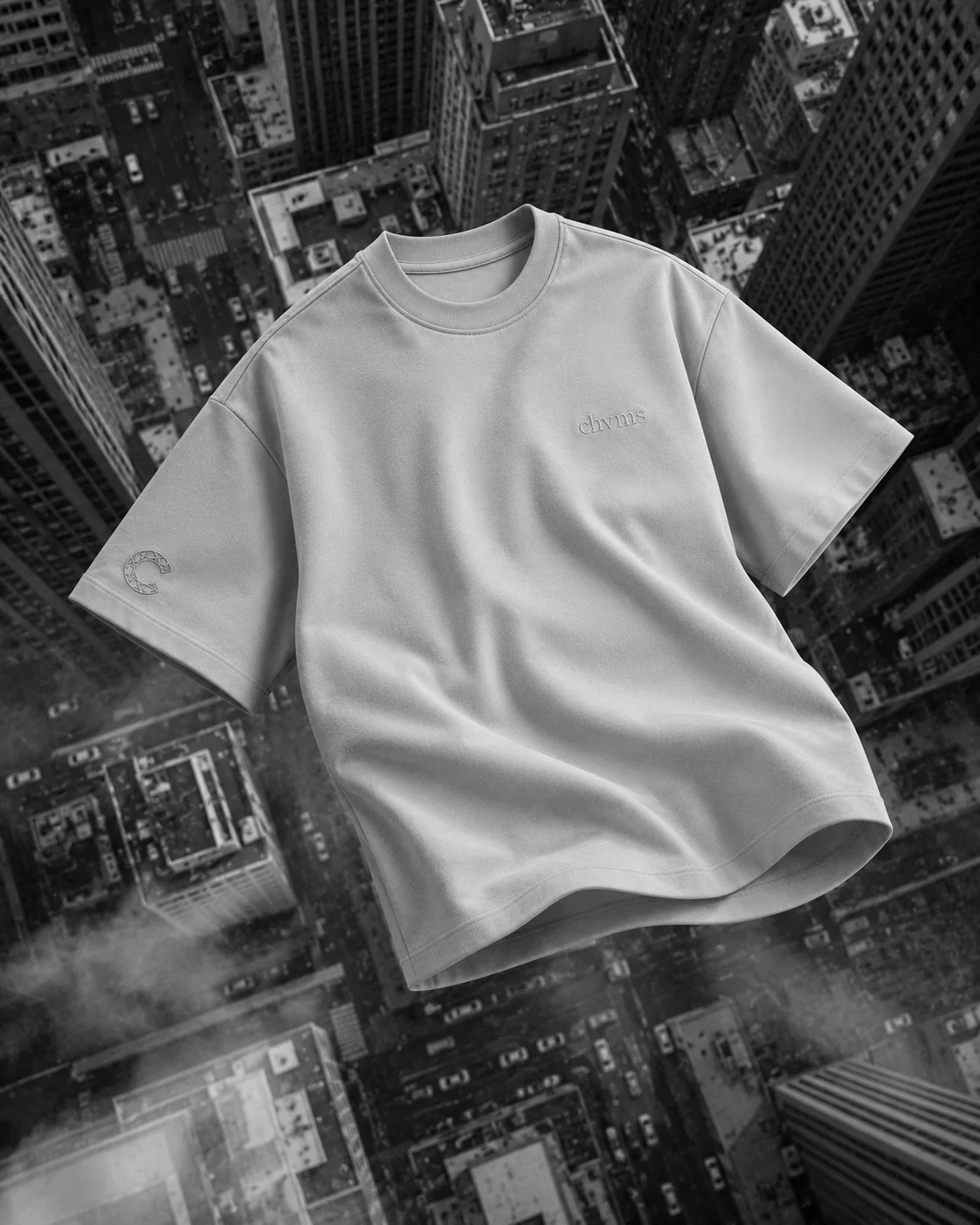 Tee oversize sable CHVMS en lévitation au-dessus d'une ville vue du ciel